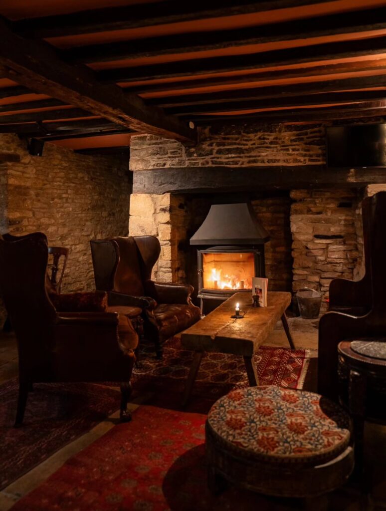Log fire and armchairs in the stone-walled lounge at The Mason’s Arms, Clanfield